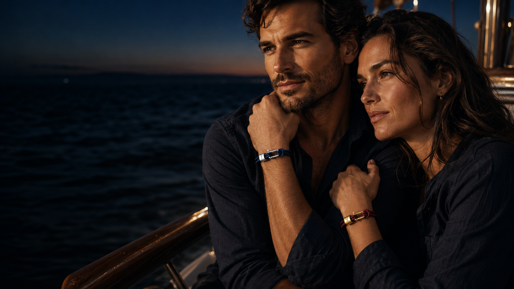 Couple on a sailboat at dusk wearing VIREL navy and bordeaux nautical rope shackle bracelets